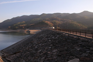Vista del terrapieno sul lato lago della diga dalla sponda destra.