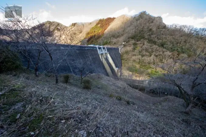 Vue de la face aval de la digue du barrage de Kawamoto depuis la rive droite.