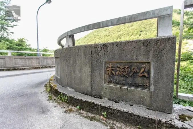 Placa con el nombre de la presa de Akase en la orilla izquierda